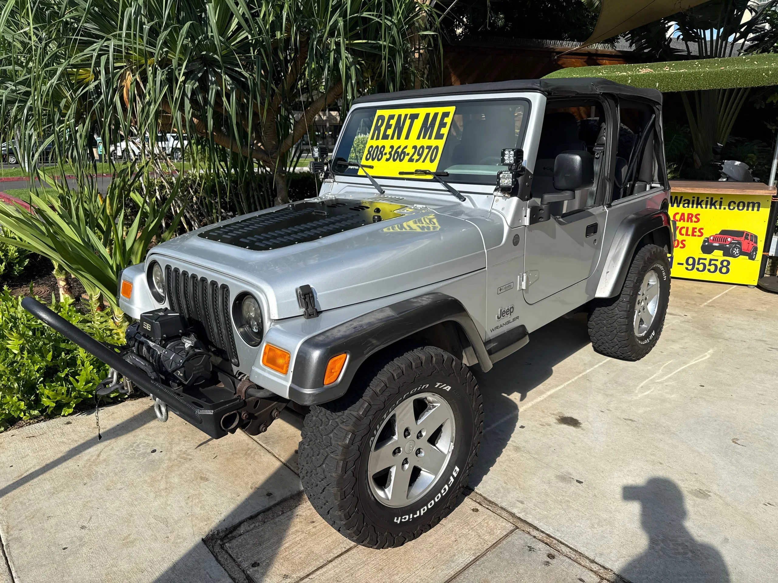 Silver vintage Jeep parked for Waikiki rental