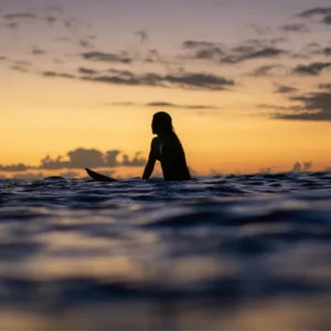 Boat floating on turquoise water at sunrise
