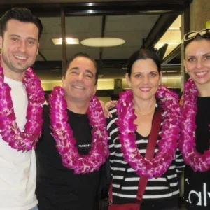Family receiving fresh flower leis at airport arrival