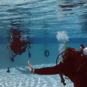 Child practicing scuba breathing in swimming pool