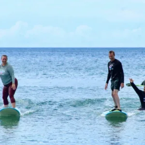 Two people learning to surf together on a sunny beach