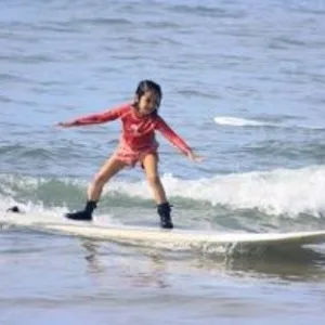 Two people learning to surf with instructor guidance