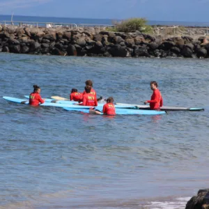 Group of three or more surfers getting ready